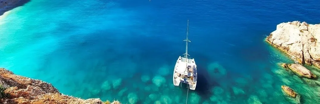 Catamaran anchored in calm bay, ionian islands.