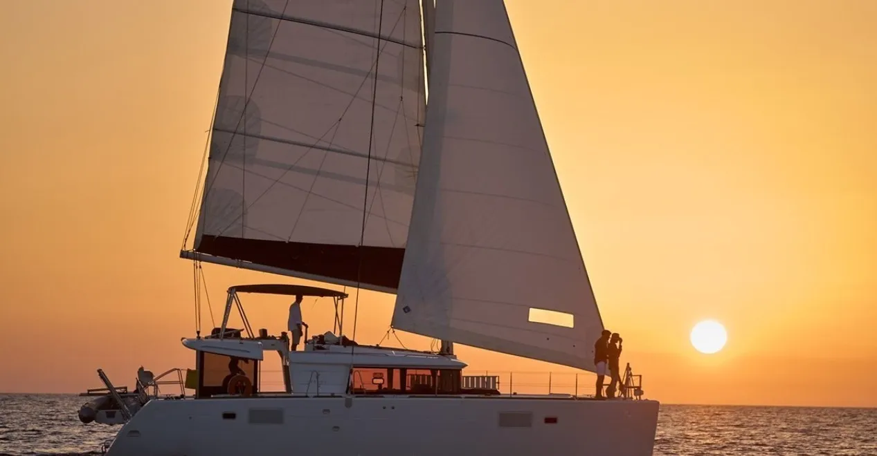 A Lagoon 450F sailing at sunset.