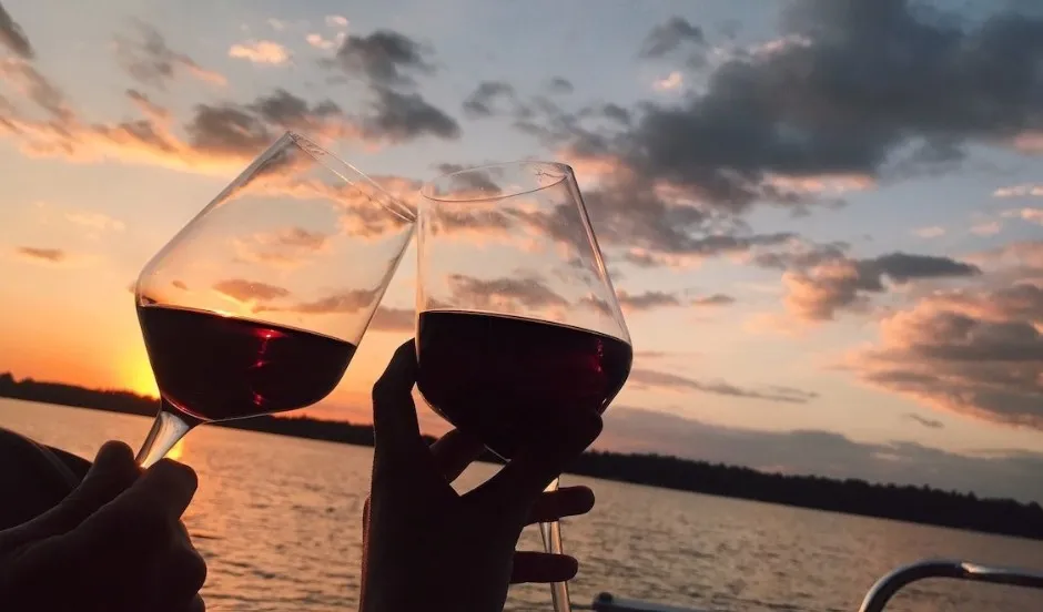 Enjoying a glass of wine onboard catamaran during sunset.